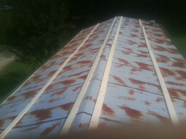 Rusted metal roof panels with new wood purlins before replacement — Storm Damage Roof Repair in Traphill by Roofing Brothers